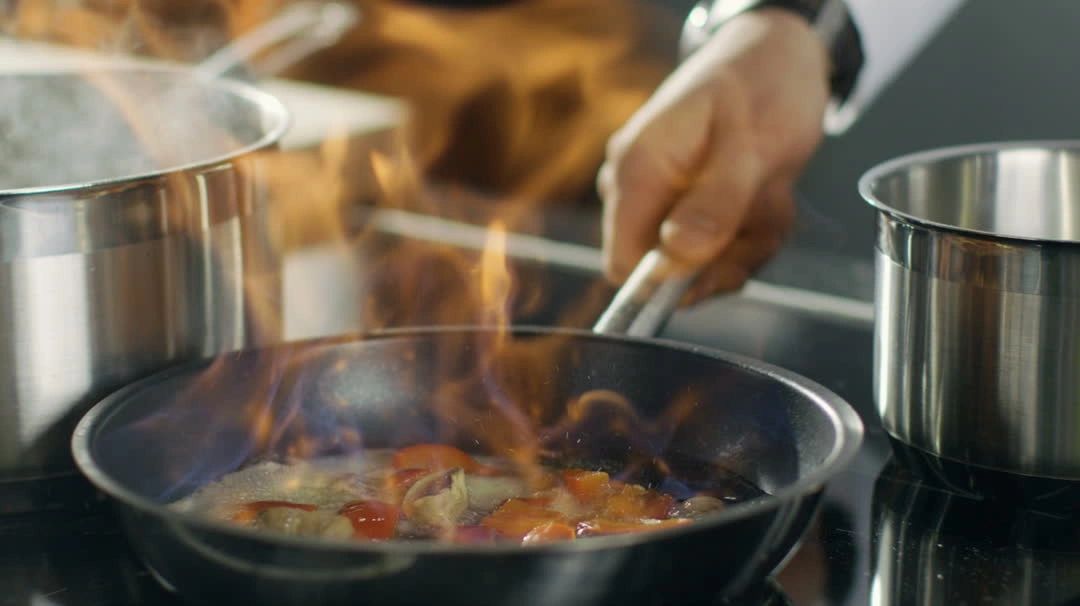 Chef Rhonda cooking with flames — high-heat culinary technique